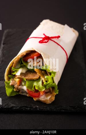 Döner Kebab oder Shawarma Sandwich auf schwarzem Schiefer Hintergrund Stockfoto