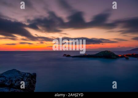 Felsigen Ufer des Meeres. Sonnenuntergang im Himmel mit Wolken Stockfoto
