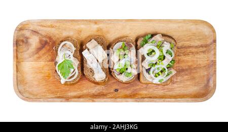 Blick von oben auf die verschiedenen Open Sandwich mit rollmops auf Holzplatte auf weißem Hintergrund Stockfoto