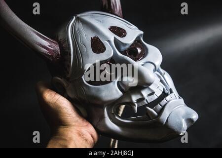 Japanische oni Maske oder riesige Maske, verwendet in Handarbeit aus original zu dekorieren, damit es dunkel und Kunst betrachten, es mit der Hand berühren. Stockfoto