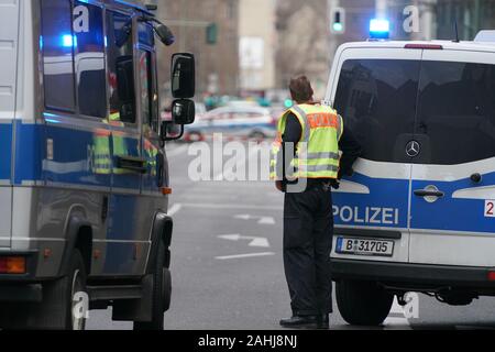 Berlin, Deutschland. 30 Dez, 2019. Fahrzeuge der Polizei blockieren die Straßen rund um die Kreuzung Kochstraße Friedrichstraße in der Nähe von Checkpoint Charlie. Credit: Kay Nietfeld/dpa/Alamy leben Nachrichten Stockfoto