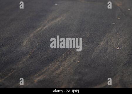 Weichen glatten schwarzen Sand Textur auf dem Strand mit Kiesel um Mix mit normalem Sand Stockfoto