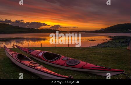 Sonnenuntergang mit zwei Seekajaks bei Dunvegan auf Skye, Schottland Stockfoto