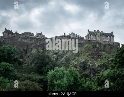 Blick auf die Burg von Edinburgh von der Princess Street Gardens an einem bewölkten Tag. Stockfoto