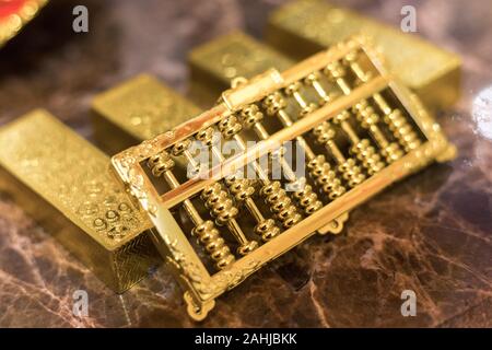 Ein Kilo Gold auf Luxus Marmortisch zusammen in einer Reihe mit goldenen Abacus auf. closeup Stockfoto