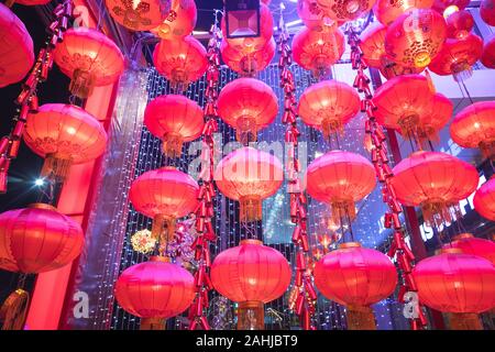 Viele chinesische Laternen hängen mit einer anderen in der Zeile Muster auf der Oberseite der Decke in der Nacht mit einigen Dekoration und LED-Licht im Hintergrund Stockfoto