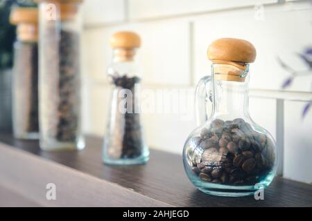 Kaffee Samen in vintage Flasche wie Wissenschaft runde Flasche, die auf Regalen für Dekoration im Cafe Stockfoto