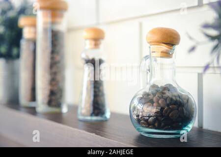 Kaffee Samen in vintage Flasche wie Wissenschaft runde Flasche, die auf Regalen für Dekoration im Cafe Stockfoto