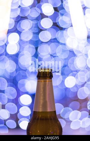 Top Bier Flasche mit blur weißes LED-Licht auf blauem Hintergrund Stockfoto