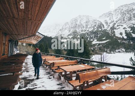 Frau Trekking in verschneiten Bergen im Winter Hohe Tatra, Slowakei. Wandern in der leeren Restaurant Terrasse in der Nebensaison Stockfoto