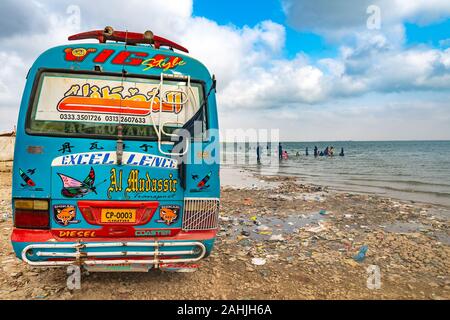 Makli Keenjhar See malerischen Blick auf einen Bus parken am Strand mit dem Gehen Besucher auf einem sonnigen blauen Himmel Tag Stockfoto