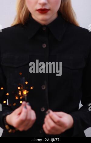 Minimalistischer Bild einer blonden Mädchen Holding funkelt. Nach oben Schließen Stockfoto