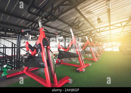 Red gym Fahrräder Ausbildung ausrichten in Muster auf Kunstrasen in Fitnesscenter Stockfoto