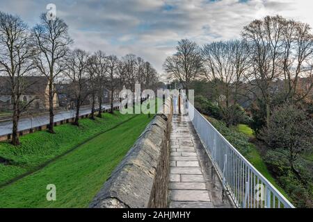 YORK CITY ENGLAND DER STADTMAUERN IM WINTER MIT MENSCHEN UND BLEIBT DER GRABEN AUF DER LINKEN SEITE Stockfoto