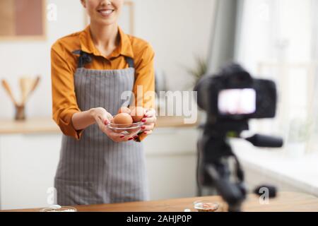 Porträt der schönen jungen Frau mit Eiern zu Kamera 7/8 während der Dreharbeiten zu backen Tutorial im Studio, Kopie Raum Stockfoto