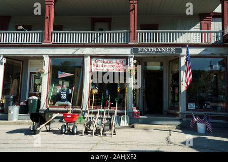 Fassade eines alten Hardware Store mit Waren auf dem Bürgersteig, Gorham, New Hampshire, USA angezeigt. Stockfoto