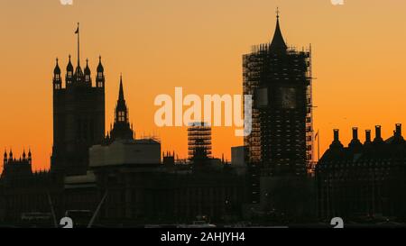 Westminster, London, 30. Dezember 2019. Die Häuser des Parlaments Silhouette bei Sonnenuntergang, mit der Elizabeth Tower noch im Gerüstbau. Ein wunderschön sonnigen Wintertag in London schließt mit einem sanften Pastelltönen Sonnenuntergang in Westminster. Credit: Imageplotter/Alamy leben Nachrichten Stockfoto