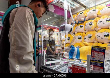 März 5, 2019: die Menschen vor einem typischen japanischen Spielzeug Kran Automaten speichern. Tokio, Japan Stockfoto