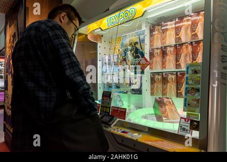 März 5, 2019: die Menschen vor einem typischen japanischen Spielzeug Kran Automaten speichern. Tokio, Japan Stockfoto