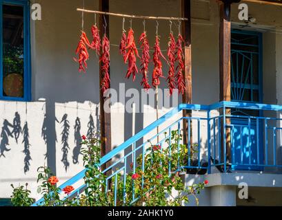 Chilischoten trocknen außerhalb eines Hauses, in dem kleinen Dorf Agios Germanos nahe Lake Prespa in der Gemeinde Prespes, Mazedonien, Nordgriechenland Stockfoto