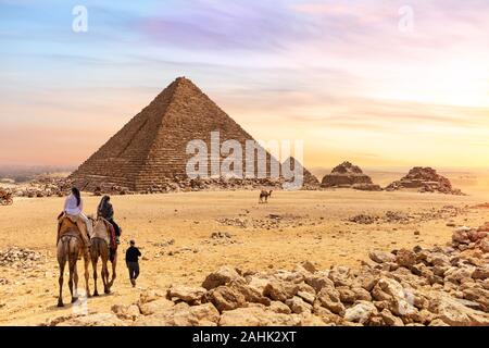 Die Pyramide des Menkaure und Touristen auf Kamelen, Giza, Ägypten Stockfoto