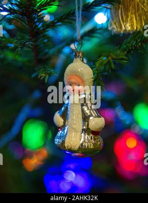 Glas Weihnachten Spielzeug snow Maiden hängend auf einer Fichte Zweig auf einen unscharfen Hintergrund Stockfoto