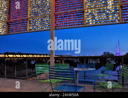 Die Seebrücke und die Skydance-Skulptur im Scissortail Park im Stadtzentrum von Oklahoma City werden bei Sonnenuntergang von der Terrasse des Boathouse aus betrachtet. Stockfoto