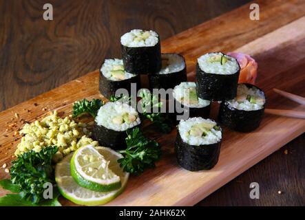 Sushi Set - Verschiedene Arten von Sushi, Maki und Nigiri Sushi. Auf dunklen Holztisch serviert. Stockfoto