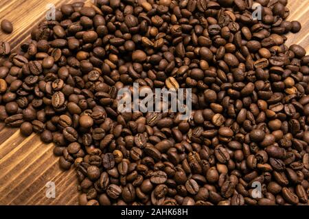 Geröstete Kaffeebohnen lose auf einem hölzernen Hintergrund Stockfoto