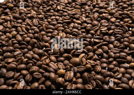 Geröstete Kaffeebohnen in loser Schüttung auf schwarzem Hintergrund Stockfoto