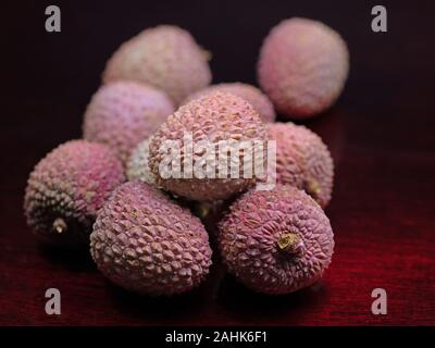 Litschis, Früchte auf rotem Hintergrund Stockfoto