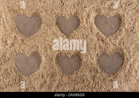 Herz Formen auf einem Hintergrund aus Sägemehl Stockfoto