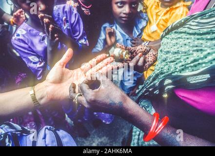 Henna, eine temporäre body art Färbung, an eine weibliche des Kaukasischen Hand in Chennai, Indien durch eine indische Frau angewendet. Stockfoto