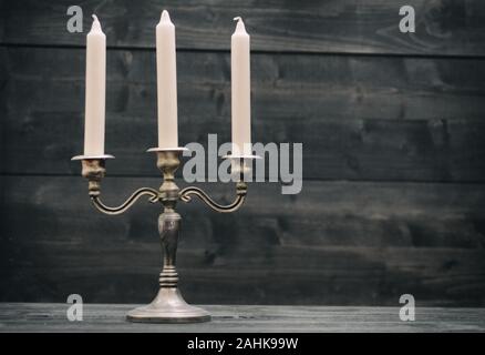 Alte vintage Kerzenhalter auf schwarzem Holz- Hintergrund. Stockfoto