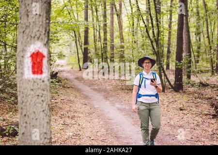 Wandern markierte Wanderweg in den Wald. Kennzeichnung der touristischen Route auf dem Baum gemalt. Touristische Route unterzeichnen. Reiseroute unterzeichnen. Touristische Wanderer mit Rucksack Stockfoto