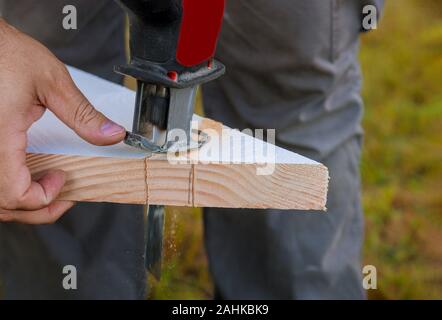 Schneiden von Holz mit einer elektrischen Stichsäge sägemehl Stockfoto