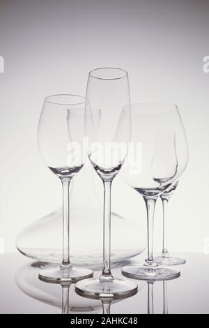 Glaswaren Auswahl mit Wein, Sekt, liquour Gläser und Dekanter auf dem hellen Hintergrund.. Feine cristal Glaswaren Konzept. Vertikale in leichte Erkältung toning Stockfoto