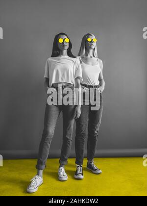 Mixed Media Plakat mit zwei Mädchen schwarz-weiß Foto mit zwei jungen Mädchen in Gelb lackiert Sonnenbrillen in Freizeitkleidung Stockfoto