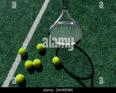Tennisplatz Draufsicht 6 Tennisbälle und -schläger auf dem grünen Gras Hintergrund Stockfoto