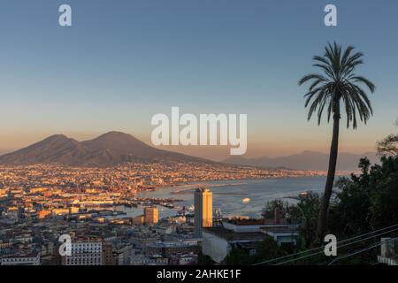 Panoramablick über die Stadt Neapel, Italien. Die Gebäude, der Hafen im Vordergrund und der Berg mit dem Vesuv im Hintergrund. Stockfoto