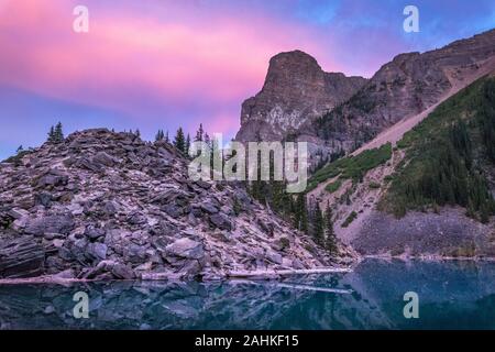 Bunter Blick auf Moraine Lake Rockpile nach Sonnenuntergang mit Spiegel - wie Reflexionen auf dem Wasser, Banff National Park, Alberta, Kanada Stockfoto