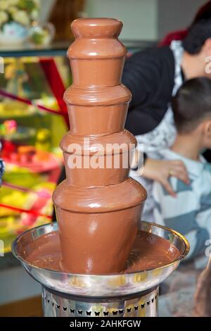 Brunnen Schokolade mit Früchten. Kindergeburtstag. Hausgemachte Schokolade Brunnen Fondue mit Marshmallow auf einem Spieß tropft in Schokoladensauce Stockfoto