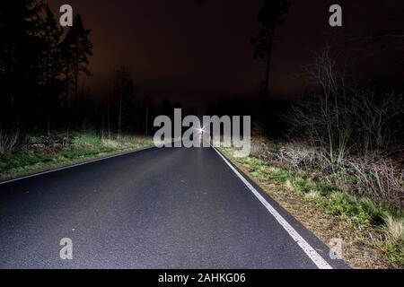 Nacht weg im Wald Foto vom Auto Stockfoto