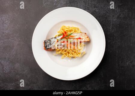 Ein Gericht der Asiatischen Lachs mit Nudeln auf einem weißen Teller Stockfoto