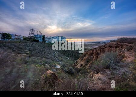 Lange Belichtung bluff Blick von oben auf die Ballona Wetlands bei Sonnenuntergang mit bunten Himmel und Santa Monica Berge in der Ferne, Playa Del Rey, Kalifornien Stockfoto