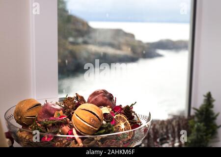 Chirstmas potpourri in einer Schüssel neben einem Fenster mit Blick auf das Meer. Stockfoto