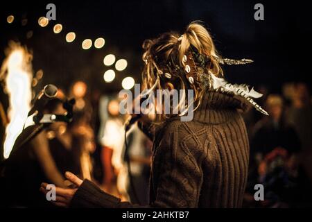 Rückseite der Musik Interpreten Gesang in der Nacht mit einheimischen traditionellen Hut. Selektiver Fokus mit unscharfem Hintergrund. Freunde tanzen um das Feuer. Stockfoto