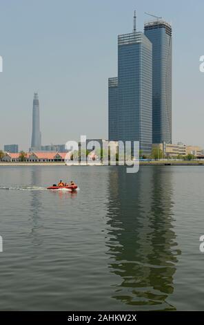 Im Bau befindliche Hochhäuser am Fluss Haihe im Binhai-Distrikt, Tianjin, China, mit dem CTF-Finanzzentrum, das sich der Fertigstellung nähert. Stockfoto