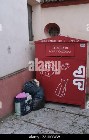 Abfall in der Nähe eines Abfallbehälters für das Recycling von Tüchern in Spanien Stockfoto