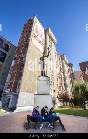 PRISHTINA, KOSOVO - November 11, 2016: Bill Clinton Statue auf Bill Klinton Boulevard mit Kosovarischen Jugendlichen sitzen vor. Die Statue war ere Stockfoto